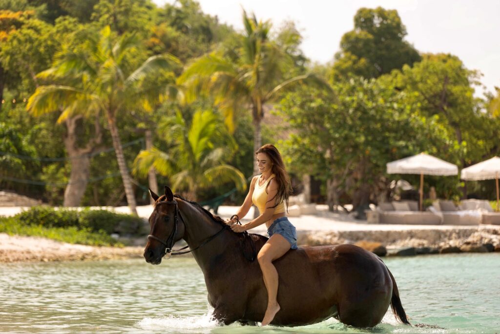 woman riding a horse as part of hippotherapy in the Caribbean