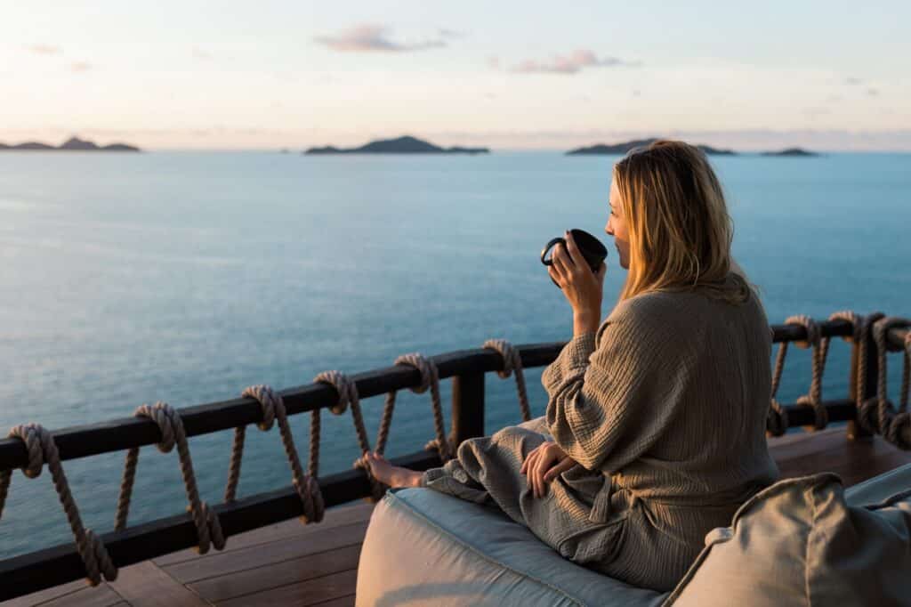 woman drinking tea while at a beachside self-discovery retreat