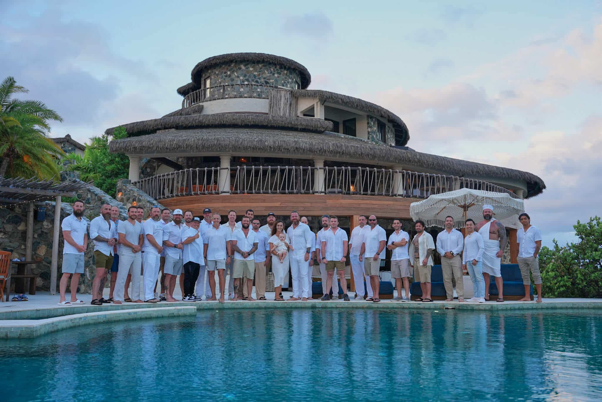 Veterans, first responders, and facilitators stand together beside the pool at The Aerial, BVI, representing community, restoration, and shared purpose.
